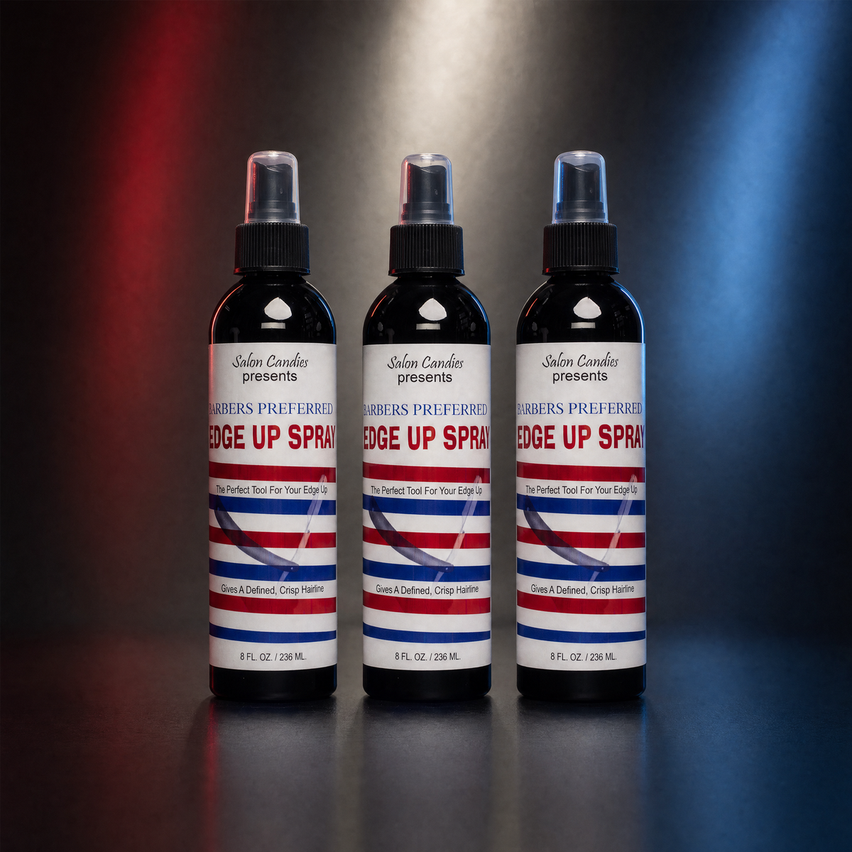 Three bottles of  Salon CandiesEdge Up Spray arranged side by side on a reflective dark surface, with red and blue spotlighting in the background.