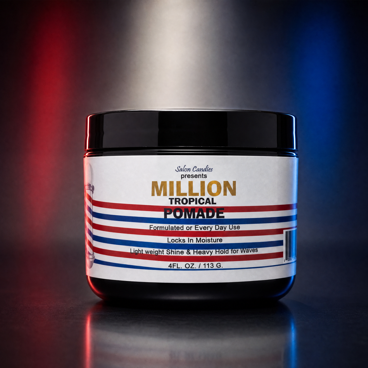 A jar of  Salon Candies Million Tropical Pomade centered on a dark reflective surface with red and blue light streaks in the background. The product is in a black plastic jar with a white label featuring red and blue stripes and gold and blue text.