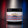 A jar of  Salon Candies Million Tropical Pomade centered on a dark reflective surface with red and blue light streaks in the background. The product is in a black plastic jar with a white label featuring red and blue stripes and gold and blue text.